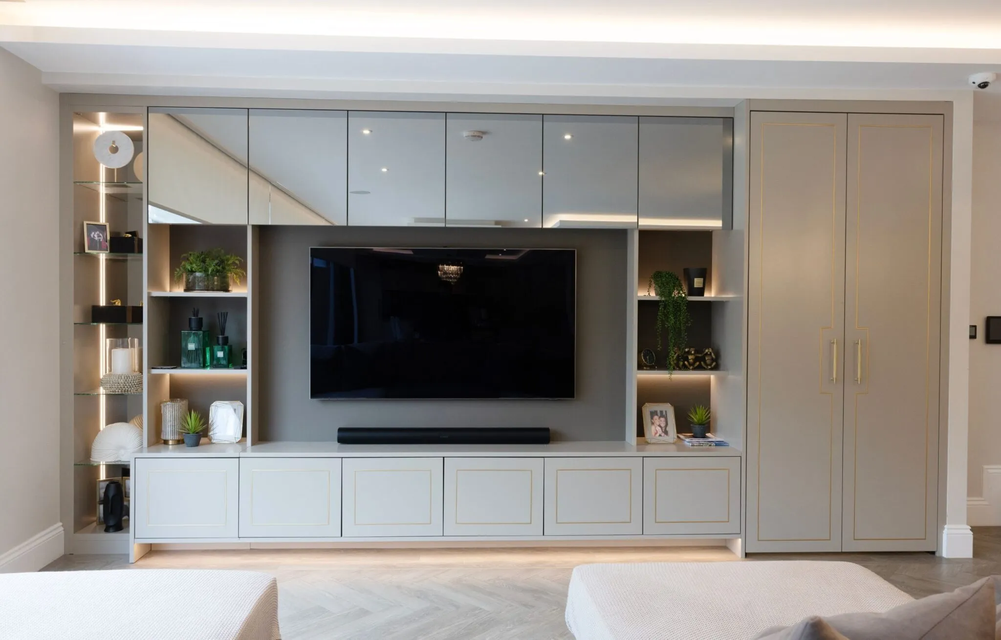 Living room TV unit in grey with mirrored cabinet doors, shelving and LED lighting