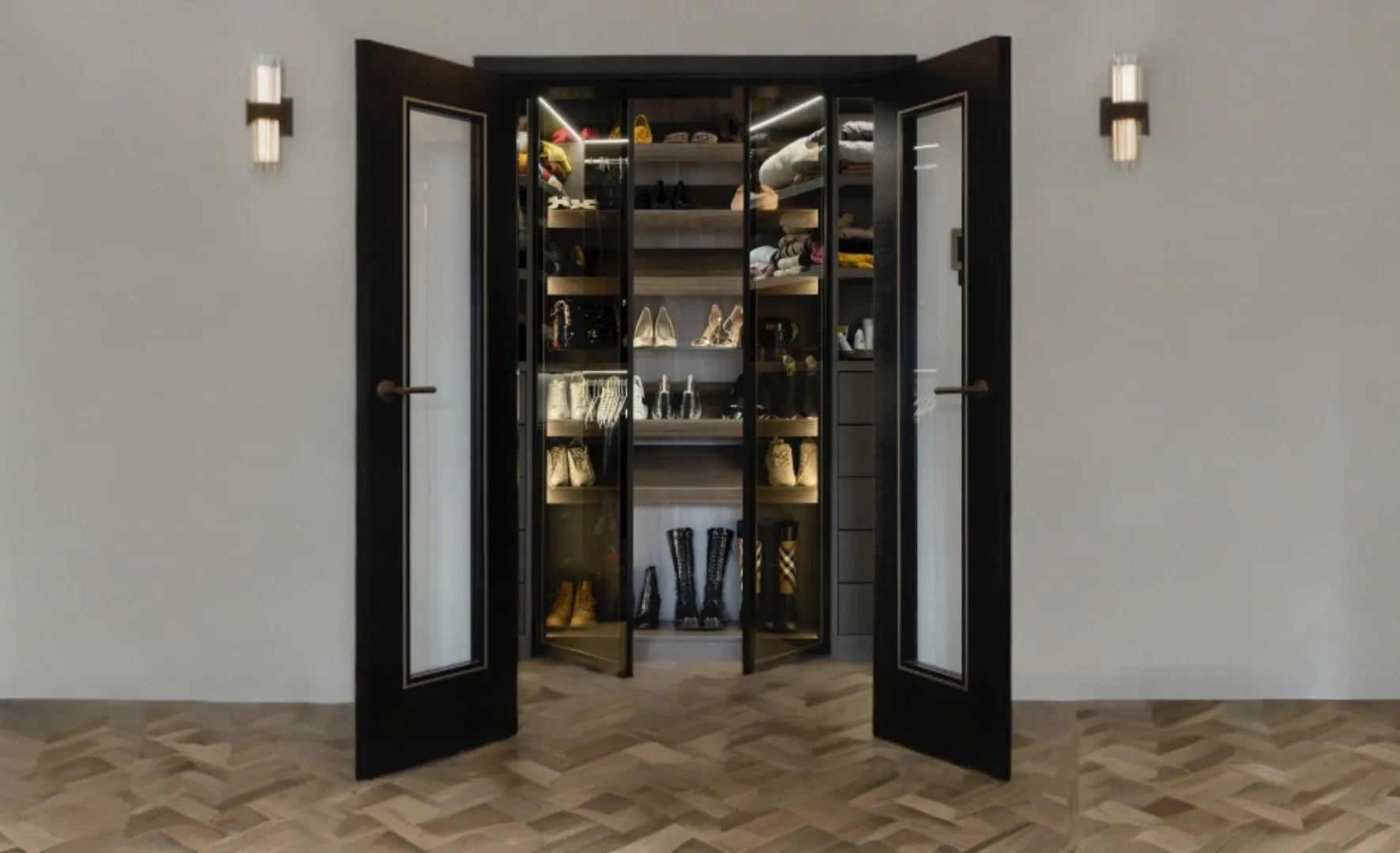 Black glazed double doors opening onto a lit shoe wardrobe with wall lights either side