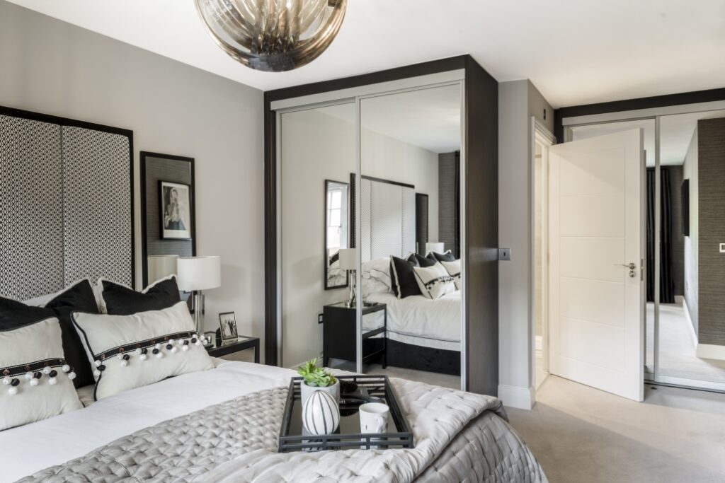 White bedroom with black accents with mirrored built in wardrobes in the Aria style